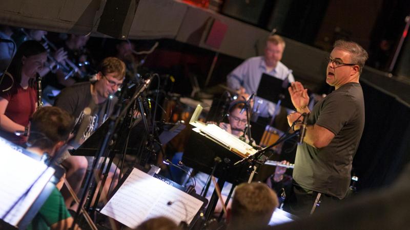 Conductor Greg Harris leads the orchestra during dress rehearsal.